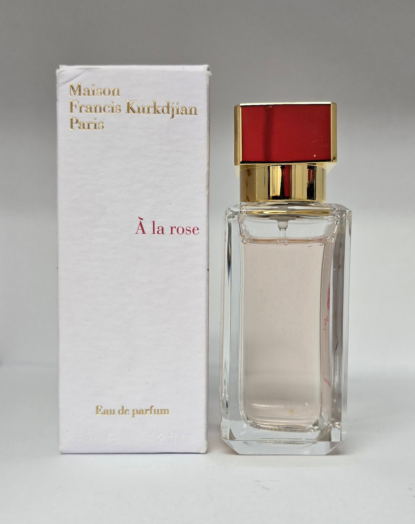 Perfume bottle and packaging of Maison Francis Kurkdjian 'A la rose' on a gray background