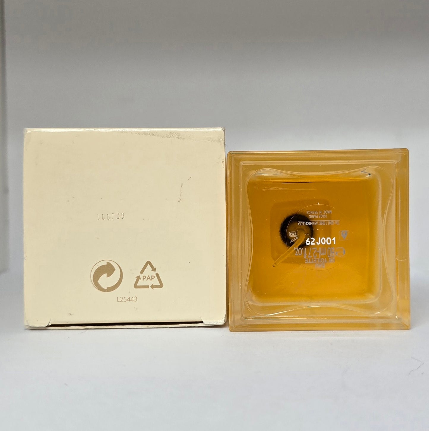 Square glass block with beige packaging on a gray background