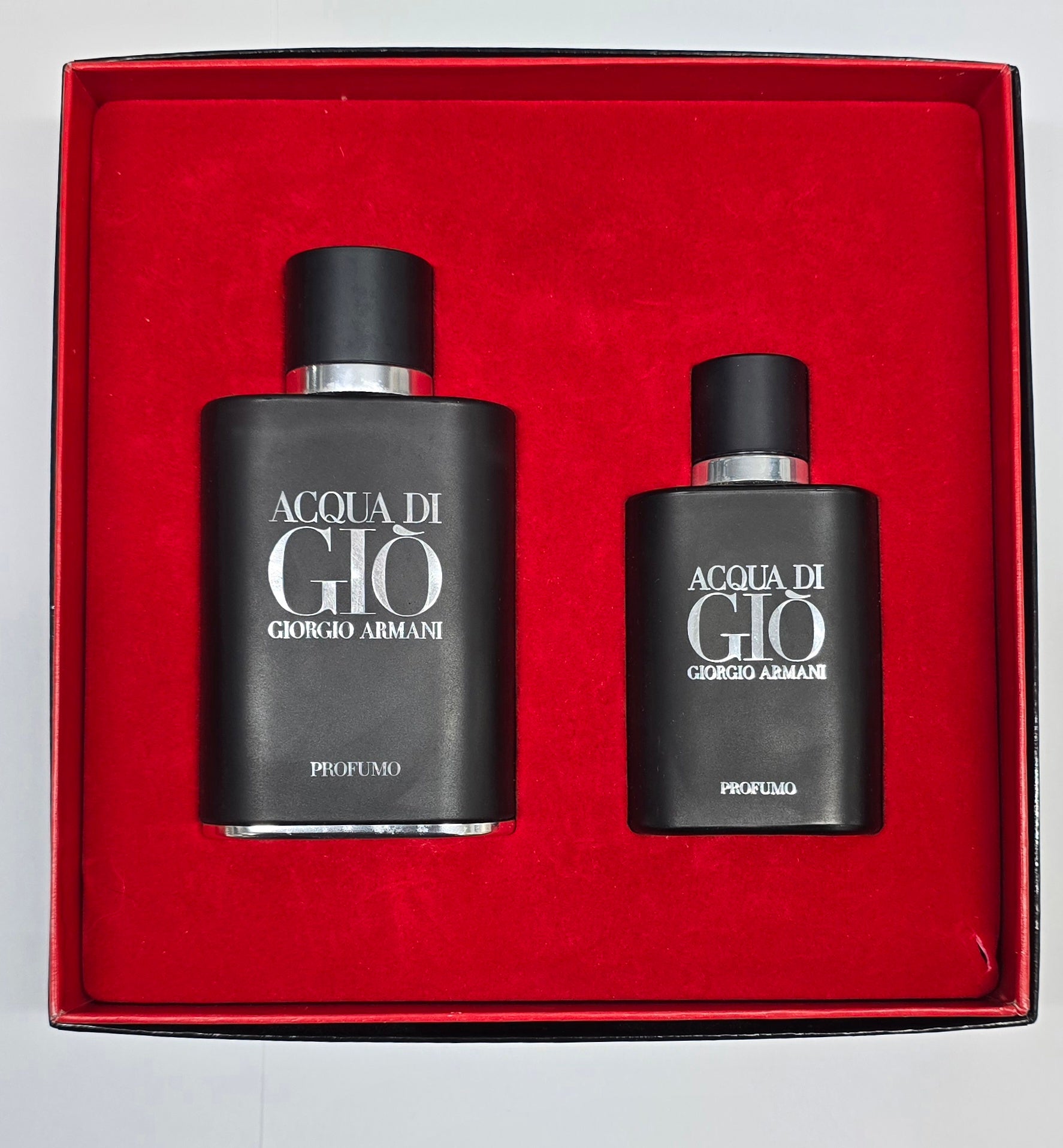 Two black perfume bottles with 'Acqua di Gio' and 'Giorgio Armani' text in a red box.