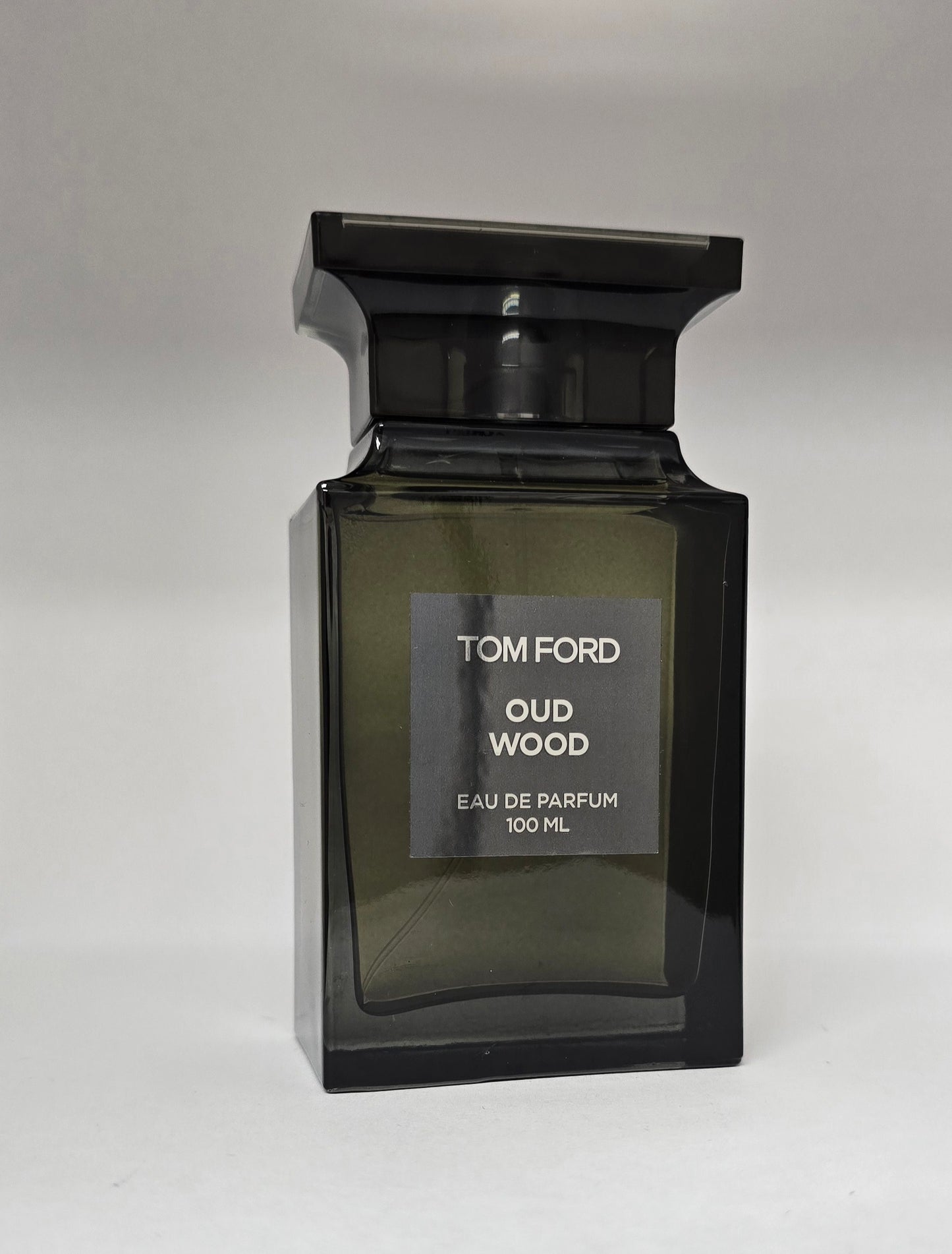 Tom Ford Oud Wood perfume bottle on a gray background