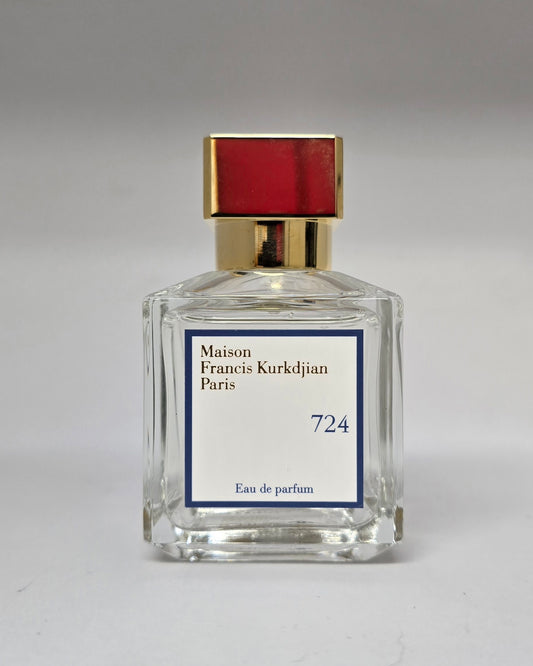 Perfume bottle with gold cap and clear glass body on a gray background