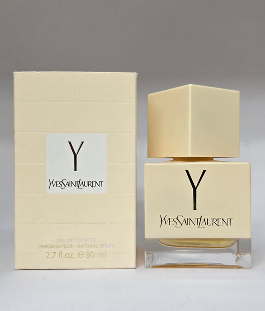 Yves Saint Laurent perfume bottle and packaging on a gray background