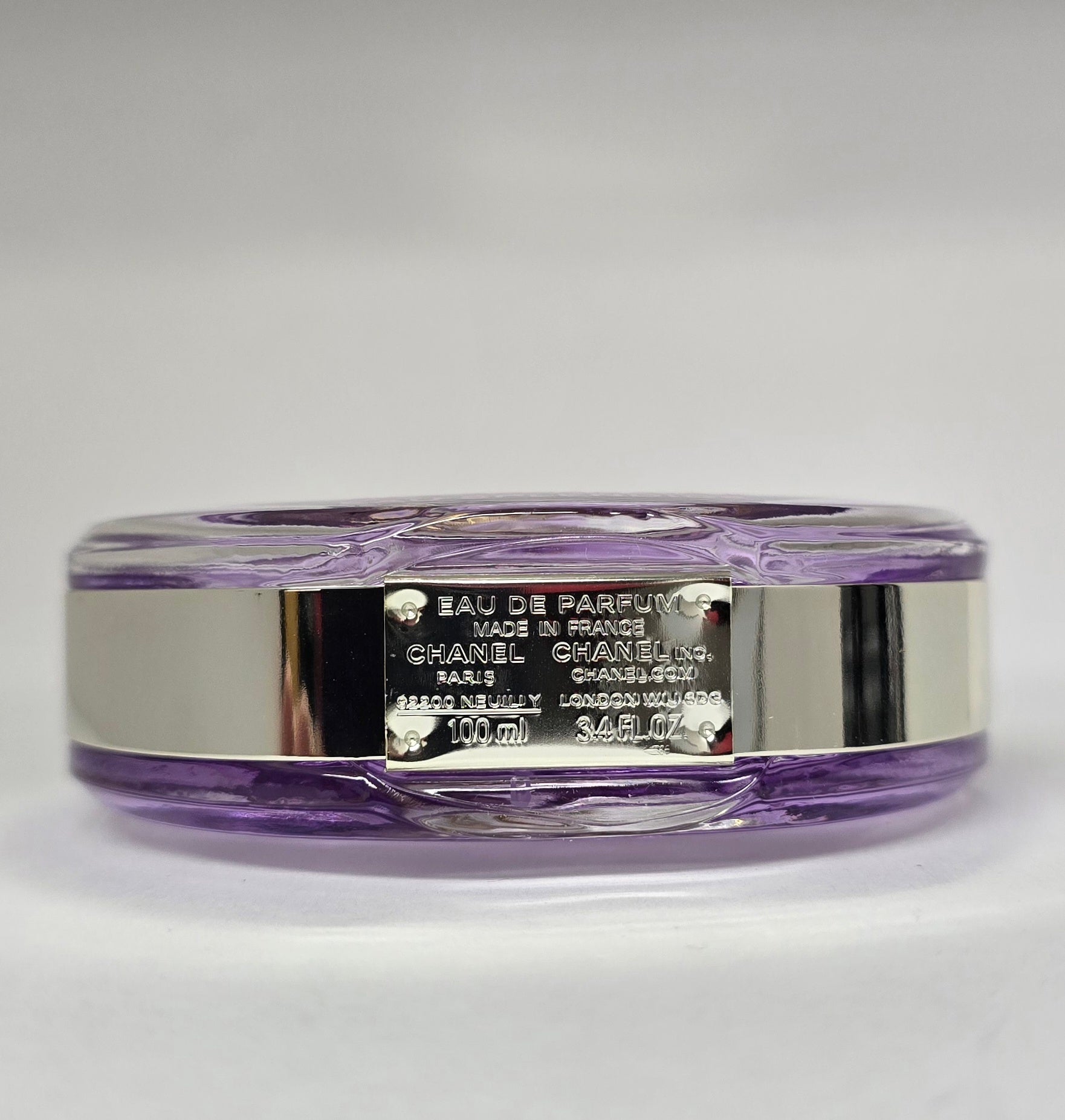 Chanel Eau de Parfum bottle with purple and silver design on a white background