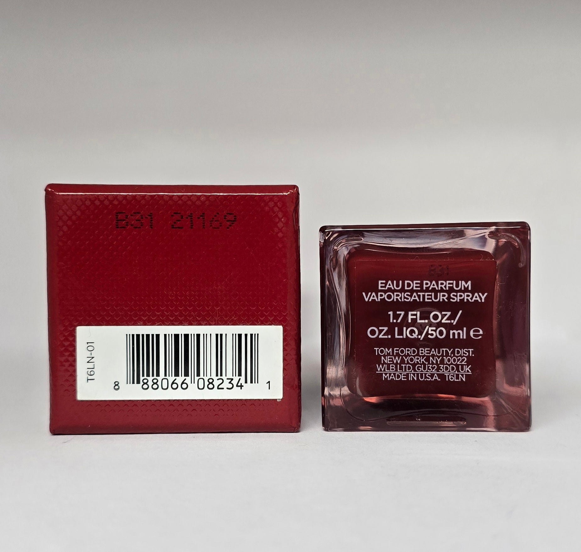Red perfume bottle and packaging on a gray background