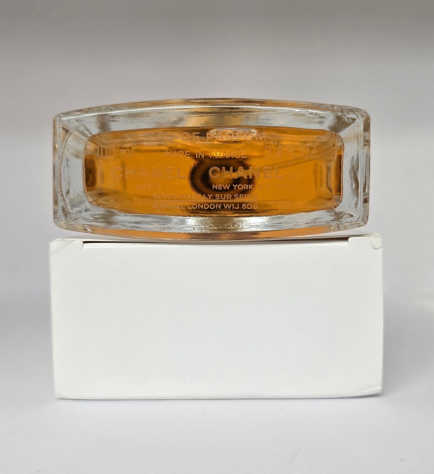 Chanel perfume bottle with a white base on a gray background