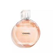 Chanel Chance Eau Vive perfume bottle with a round, translucent peach-colored glass body and a clear spray cap, set against a plain white background.